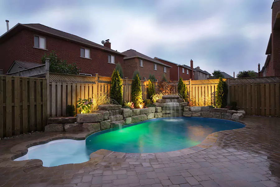 backyard pool with water features outdoor lighting