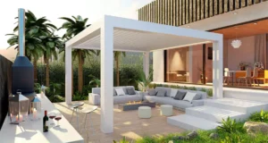 Modern white pergola with outdoor seating area, fire pit, and tropical landscaping in a contemporary backyard in Plano, TX – ideal outdoor living space for homeowners choosing between pergola vs. gazebo.