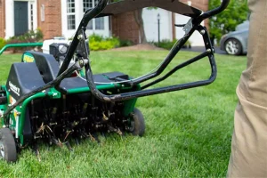 Lawn core aeration machine being used to reduce thatch buildup and improve lawn health in Prosper, TX, showcasing the benefits of professional aeration services.