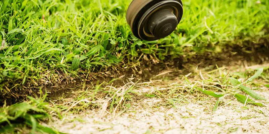 Lawn mowing machine with green grass background